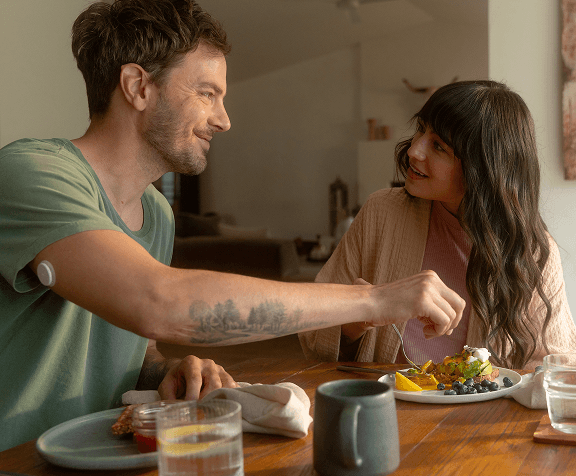 Man wearing CGM eating with woman